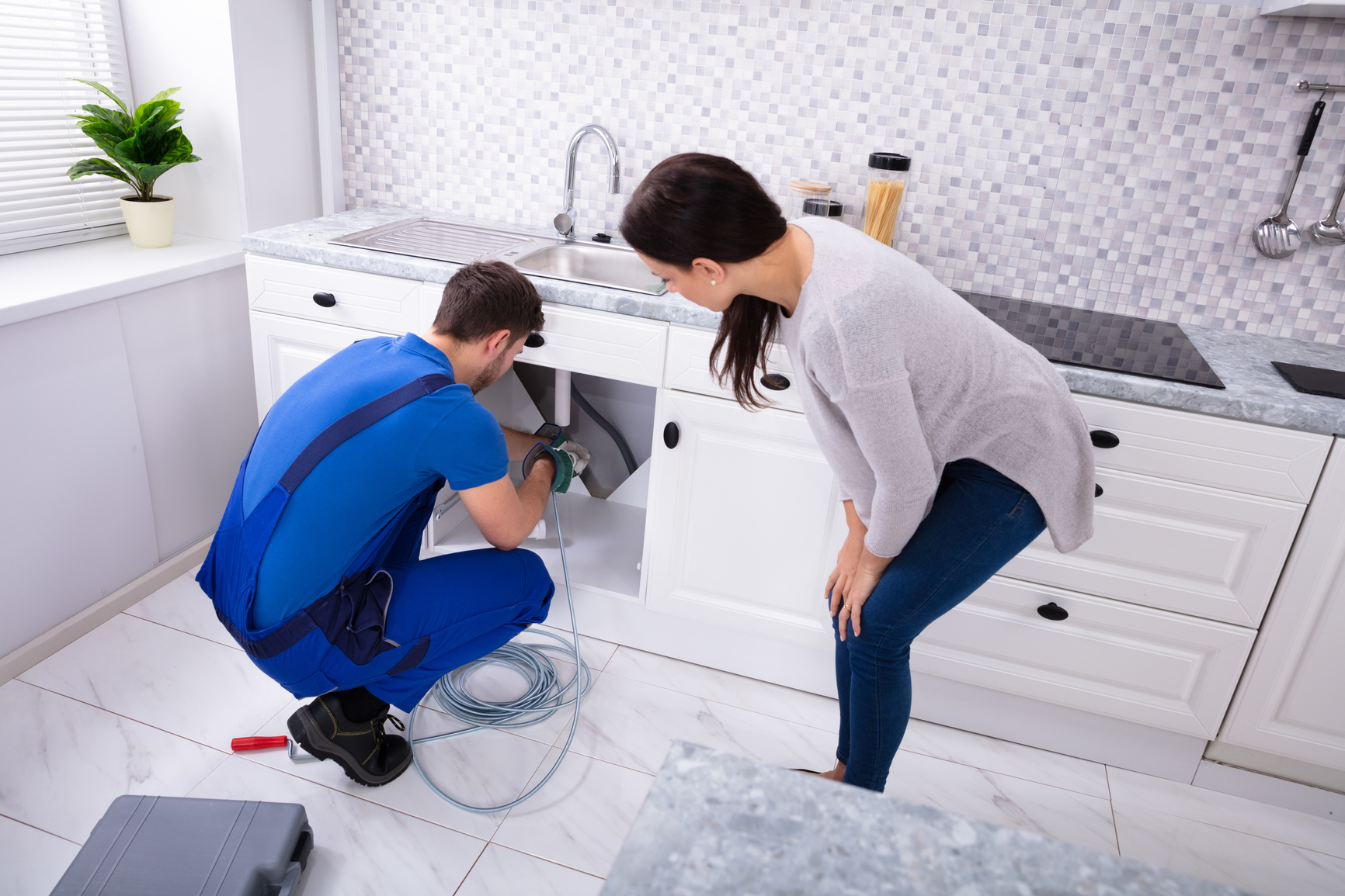 Male Plumber Cleaning Clogged Sink Pipe With Drained Cable